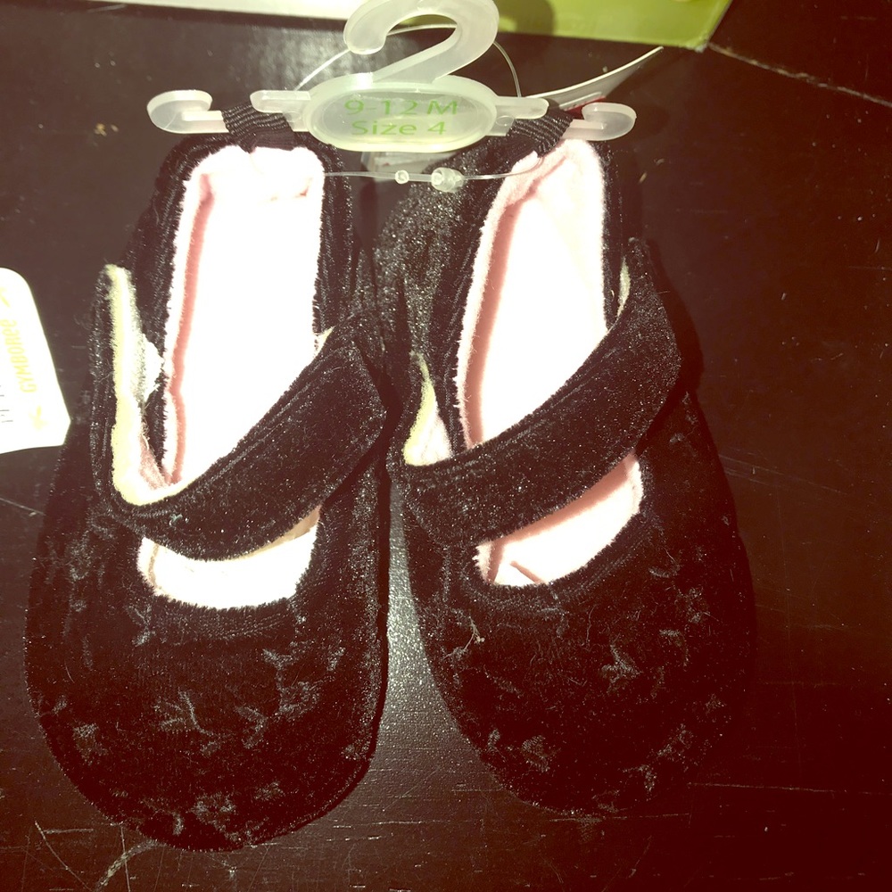 Soft black children’s shoe with flower embroidery.